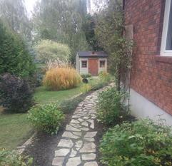 Flagstone path along the side of a brick house