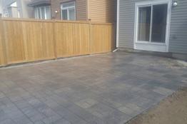 Interlock patio beside a wooden fence